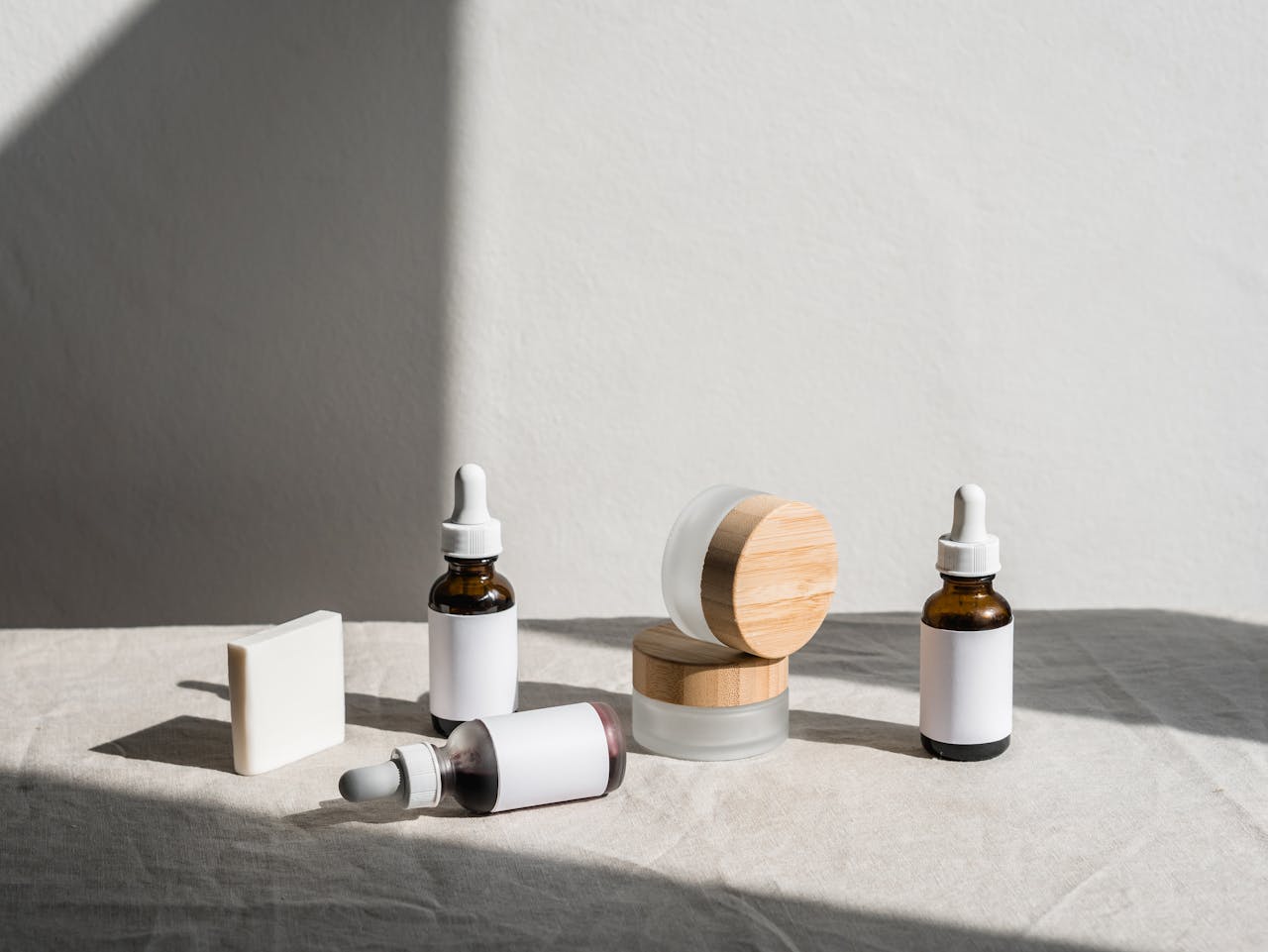 home-hero Flat lay of skincare products in jars and dropper bottles under soft natural light.
